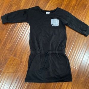 Cute black dress for kids. Has pockets and a tie waist.